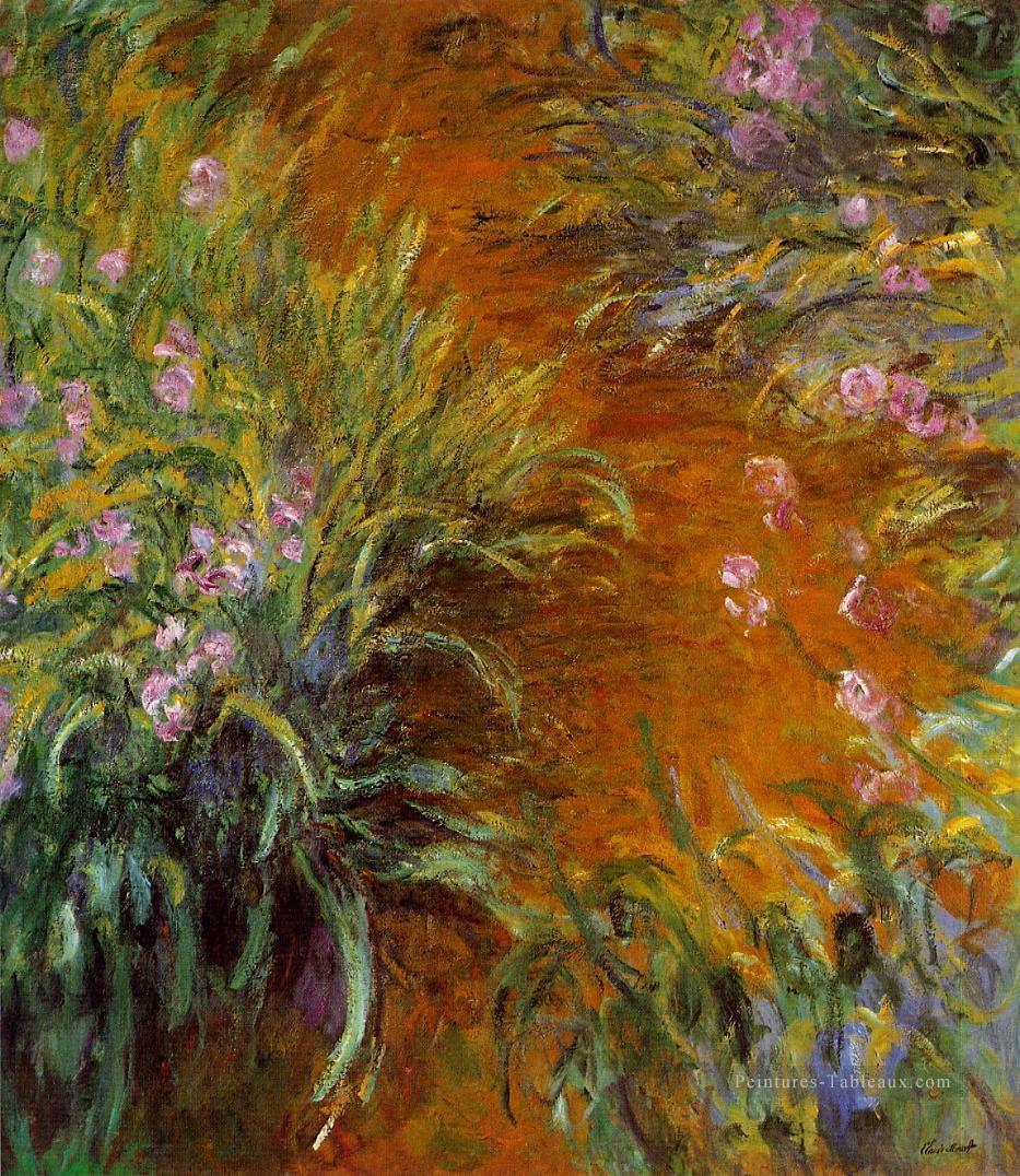 Le chemin à travers les iris Claude Monet Fleurs impressionnistes Peintures à l'huile